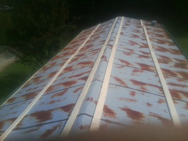 Rusted metal roof panels with new wood purlins before replacement — Storm Damage Roof Repair in Alcolu by Roofing Brothers