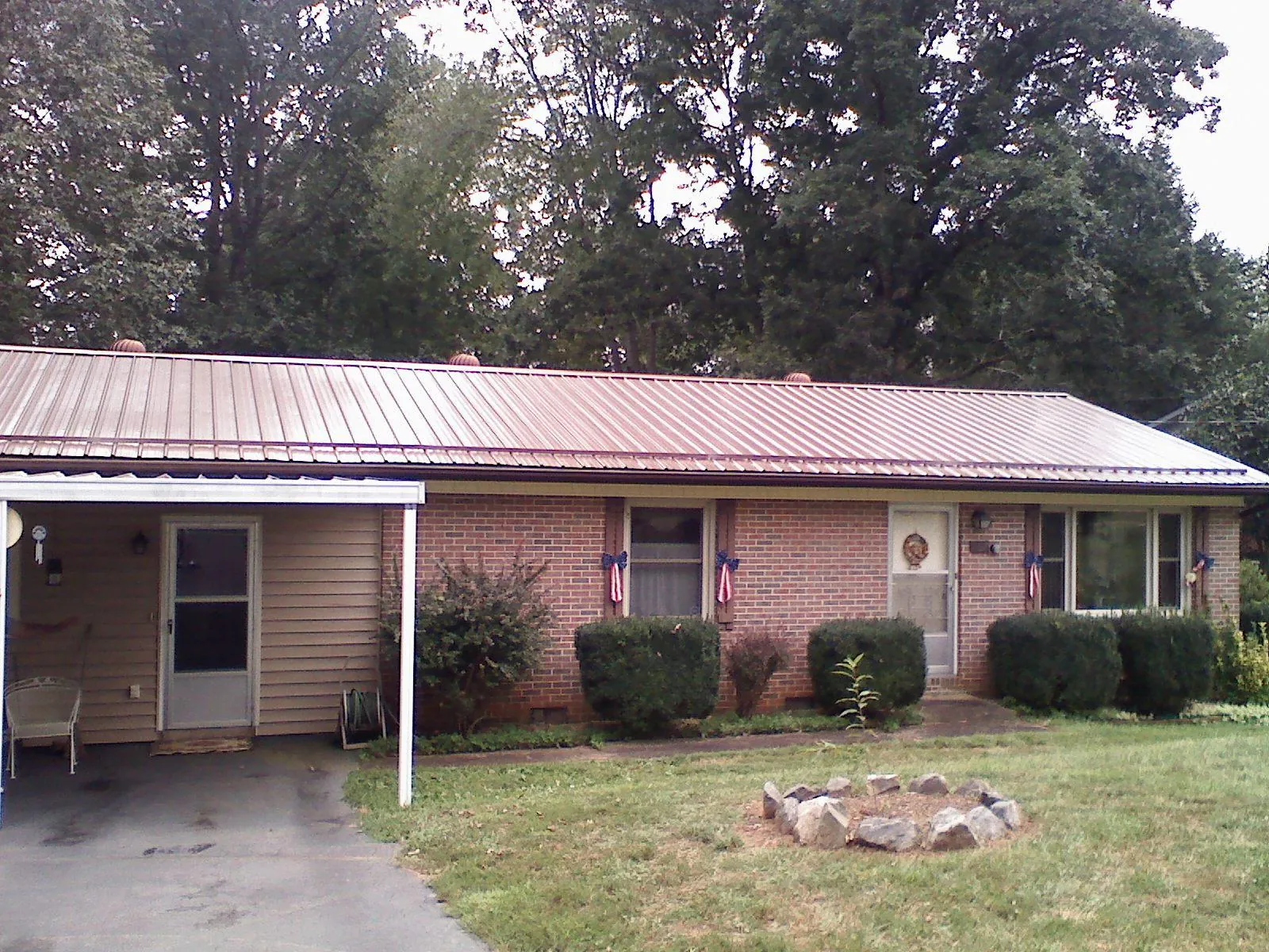 Bronze metal roof and carport on a brick ranch home — Roof Repair work by our crew in Alcolu