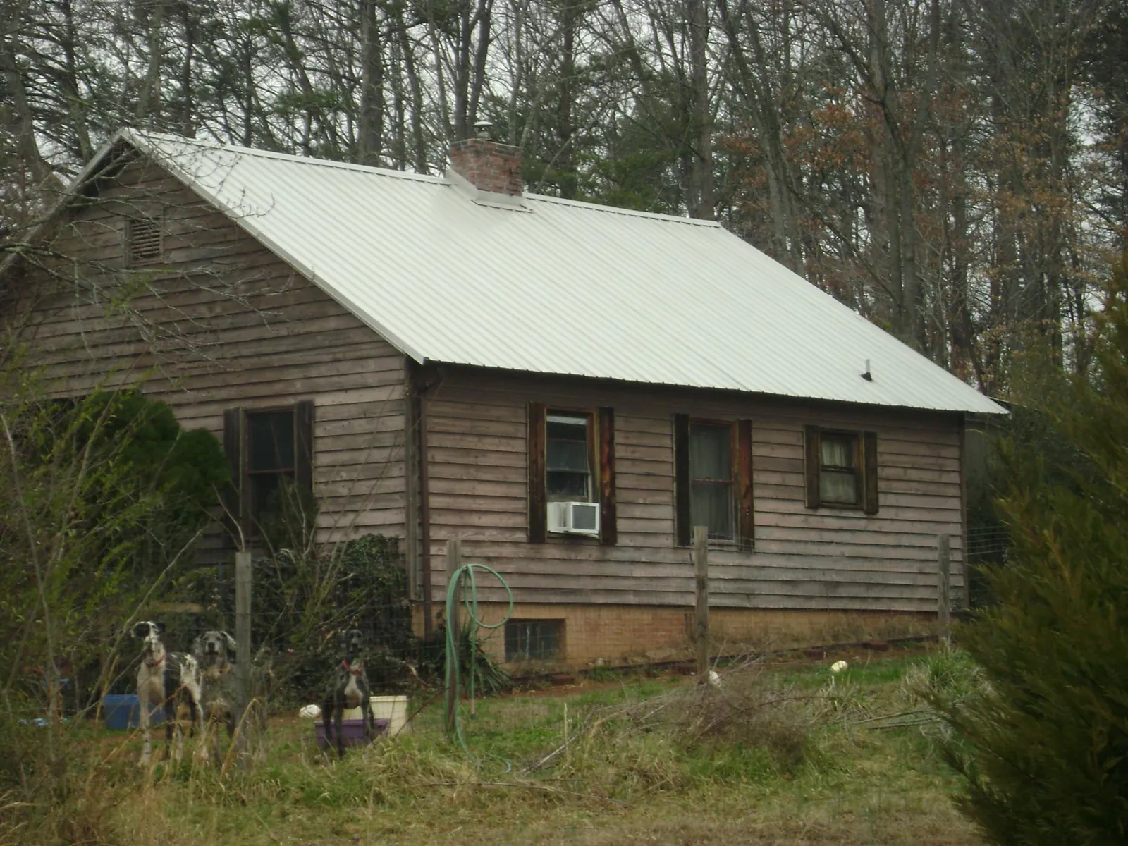 White metal roof on an old wood sided farmhouse, from a Metal Roof Installation job in Alcolu
